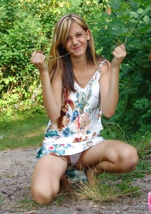 Young looking amateur flashes her upskirt panties while barefoot by trees