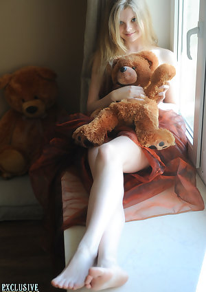 Tiny teen Kisa strikes tempting nude poses while holding a teddy bear