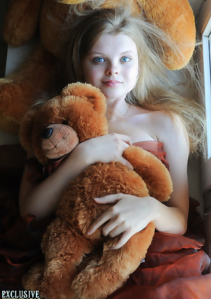 Tiny teen Kisa strikes tempting nude poses while holding a teddy bear